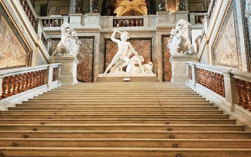 brown wooden stairs with white concrete statues